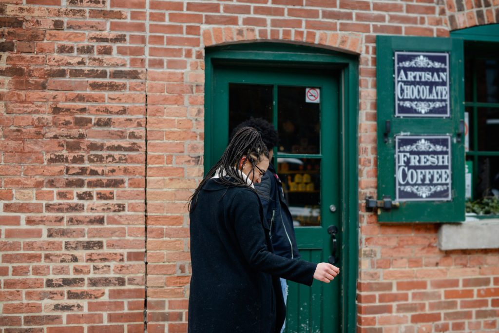 couple in front of green door and brick wall