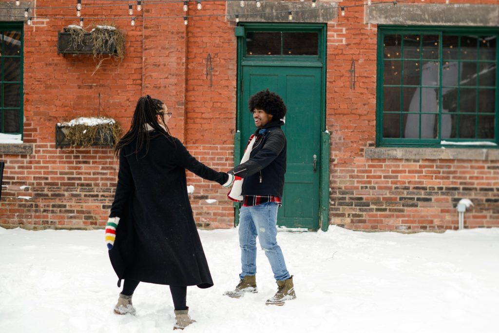 couple holding hands in the snow at an engagement photography session