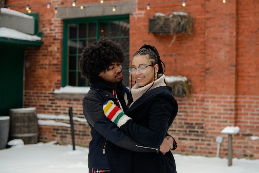 couple hugging in toronto's distillery district at engagement photoshoot