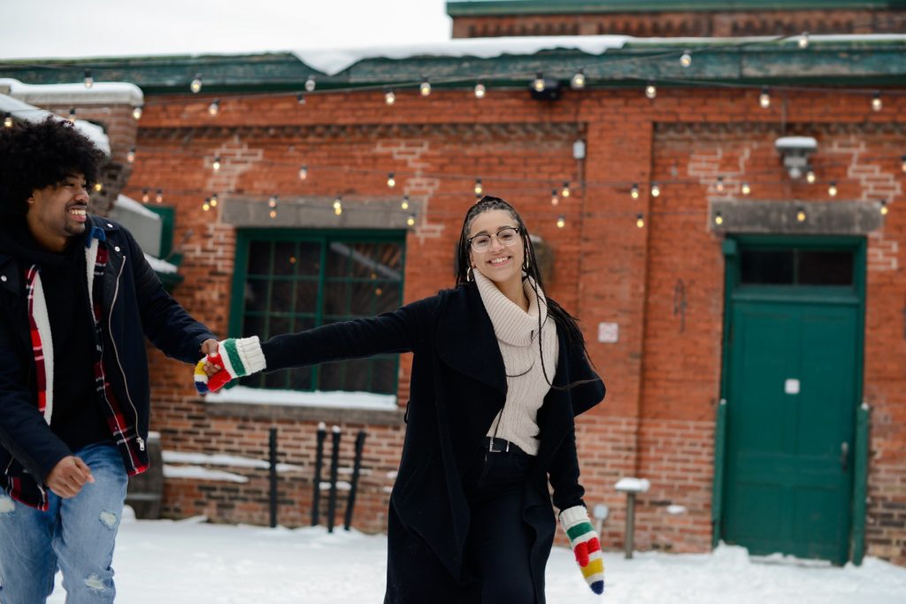 smiling woman holding man's hand at an engagement photography session