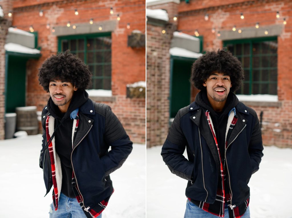 man posing in snow in front of red brick wall in toronto