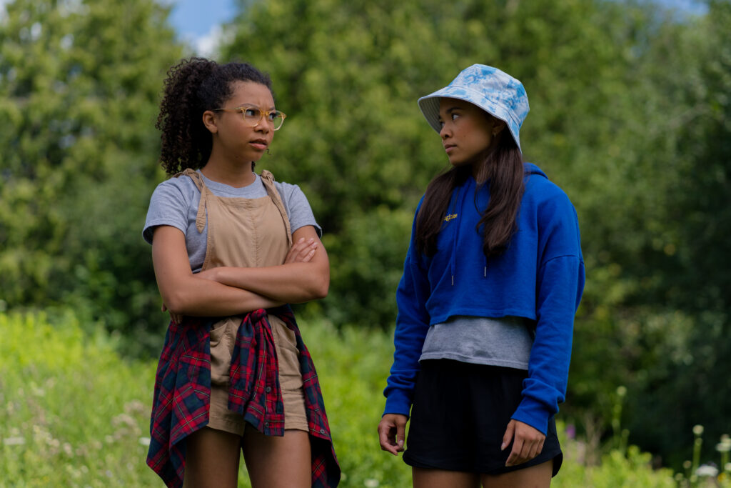 Simone Miller and Alina Prijono talk to each other outside while at Island summer camp in an episode of Detention Adventure
