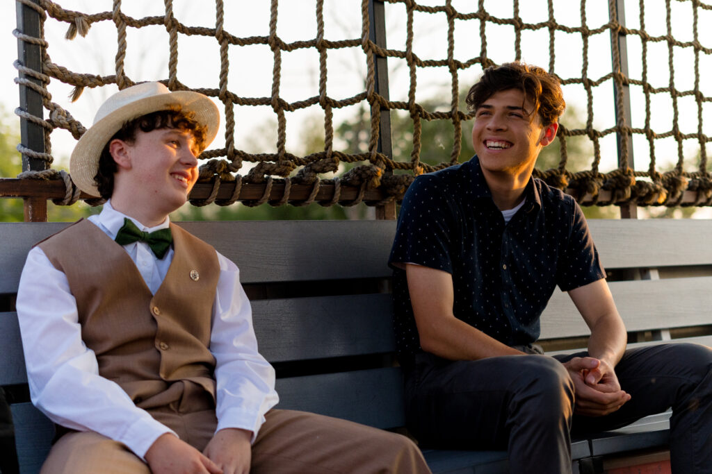 Jack Fulton and Tomaso Sanelli laugh and joke with each other on a boat ride at sunset in an episode of detention adventure