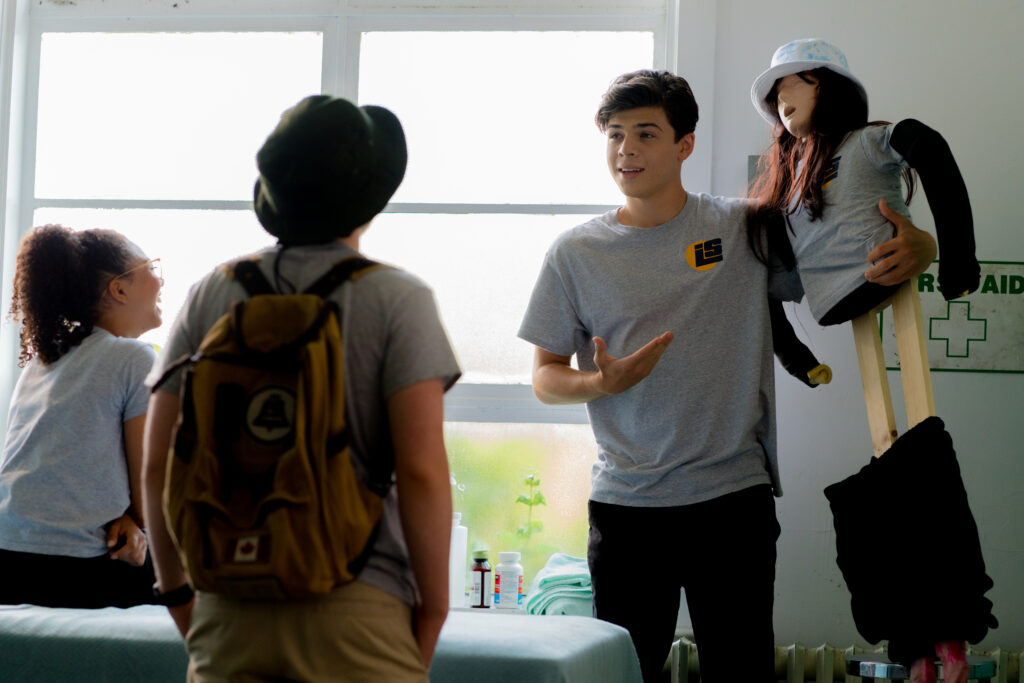 Tomaso Sanelli speak to Jack Fulton while holding up a dummy in the nurses office in an episode of Detention Adventure