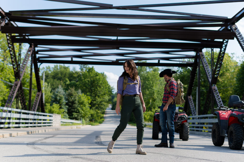 Nola Martin and Tim Rozon search for a missing wolf on a bridge in Love in Wolf Creek, a Hallmark movie