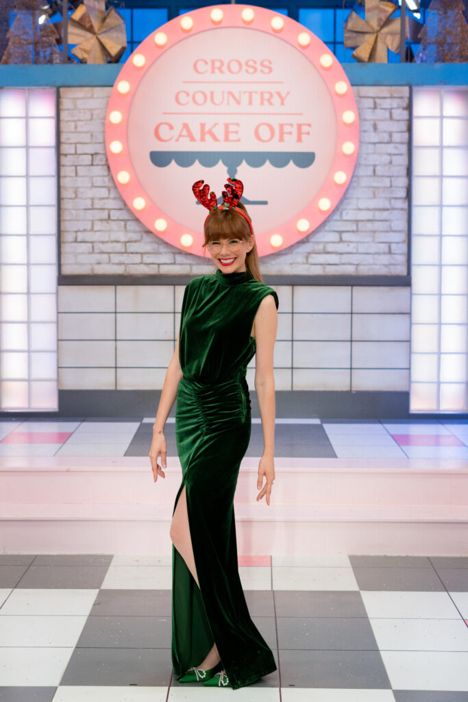 Mary Berg stands infront of Cross Country Cake Off sign