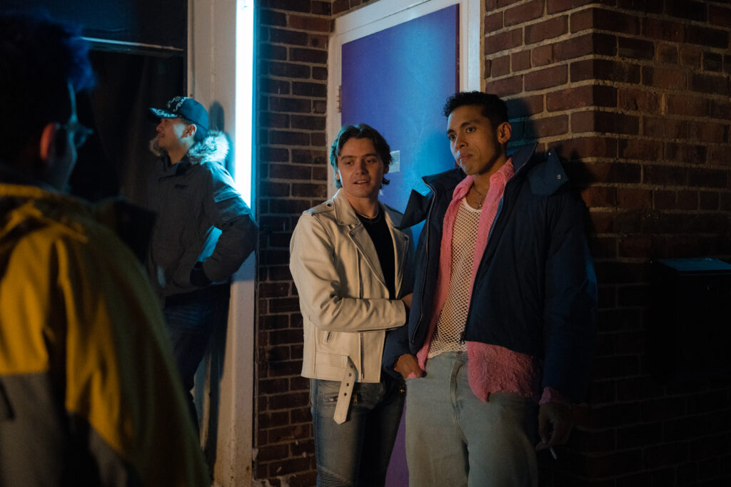 Two men look judgementally at Bobby Summers outside of a club in a scene from I Hate People, People Hate Me
