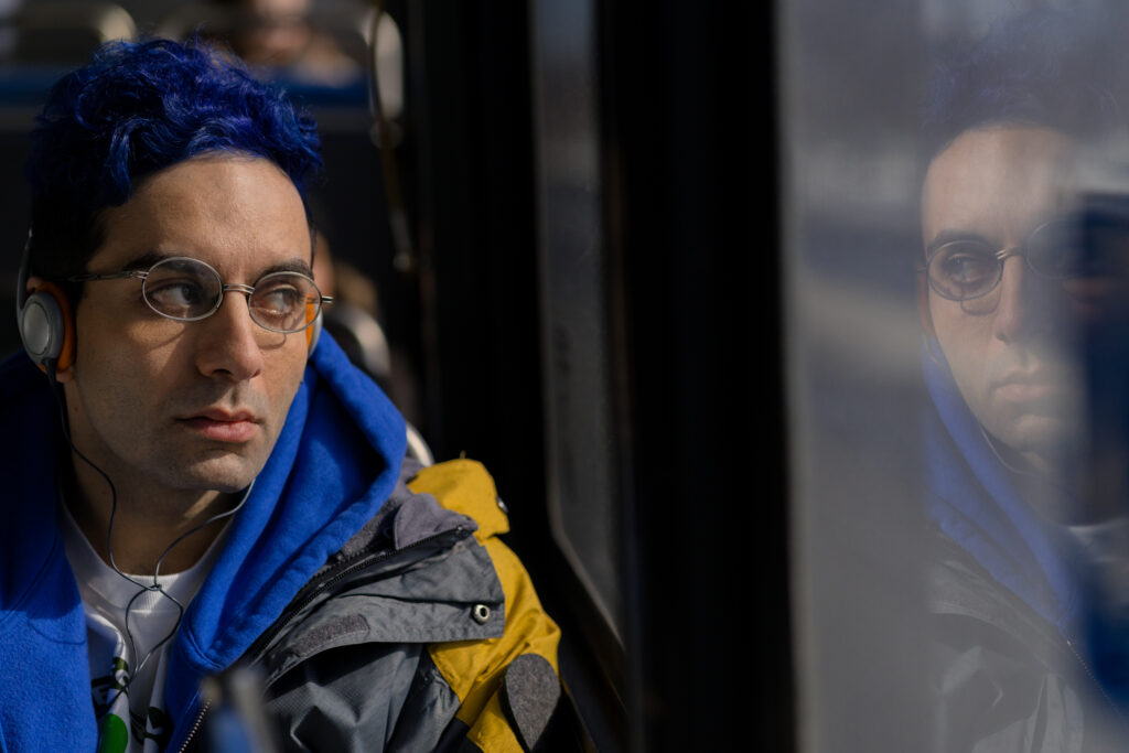 Bobby Summers looks sadly out the window of a bus in a scene from I Hate People, People Hate Me