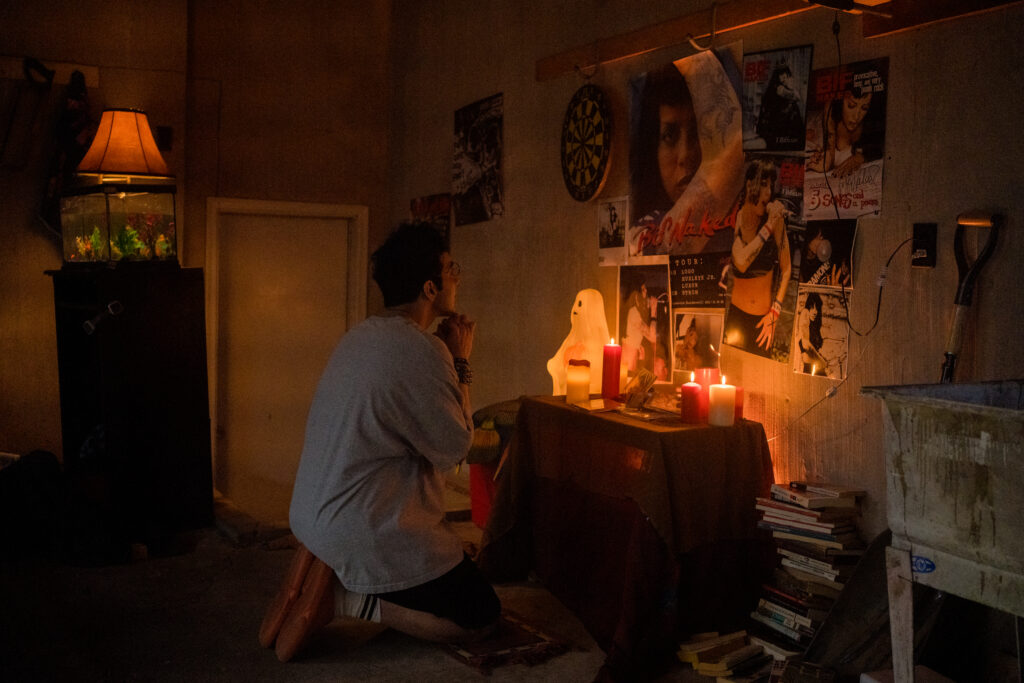 Bobby Summers prays at his alter of Bif Naked in his room in a scene from I Hate People, People Hate Me