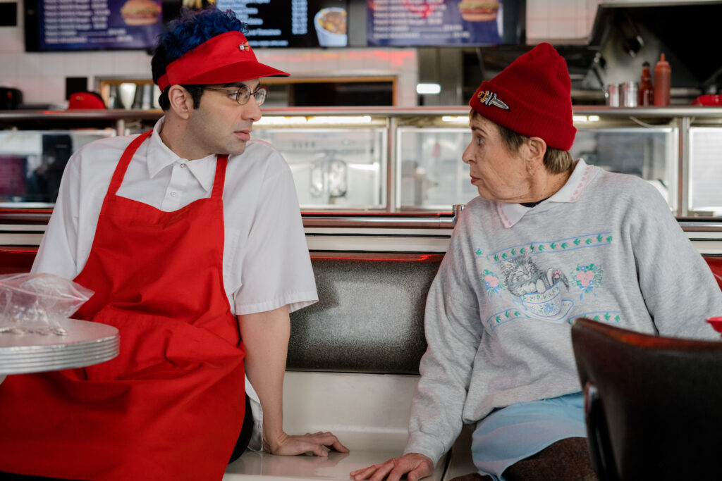 Bobby Summers talks to an older woman at his job in a fast food burger joint in a scene from I Hate People, People Hate Me
