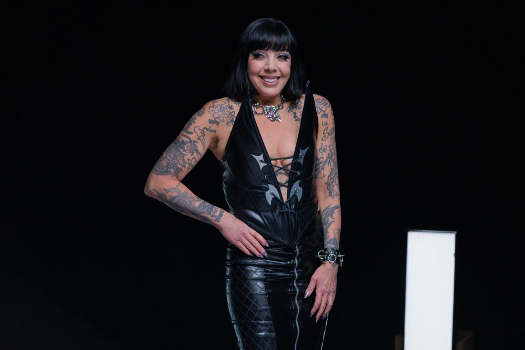 Bif Naked strikes a pose in a black vegan leather jumpsuit in a scene from I Hate People, People Hate Me