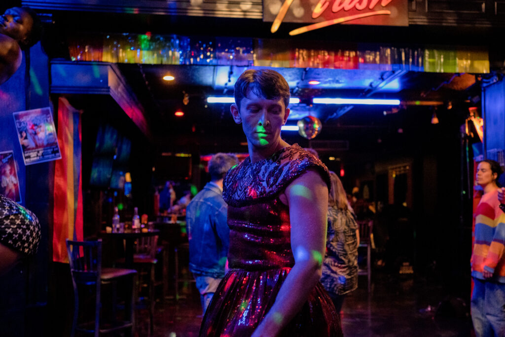 Ryan Ali stands on the dance floor in a club in a scene from the movie Queen Tut