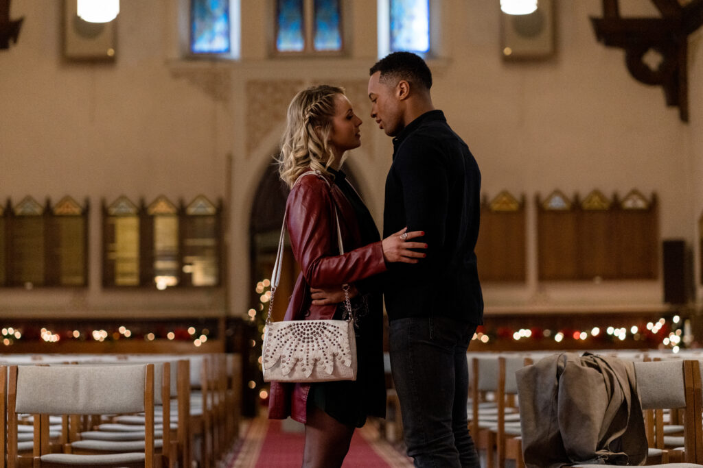 Brendan Morgan and Lanie Mcauley kiss in church Lanie Mcauley and Katerina Maria sing on stage in scene from Country Hearts Christmas