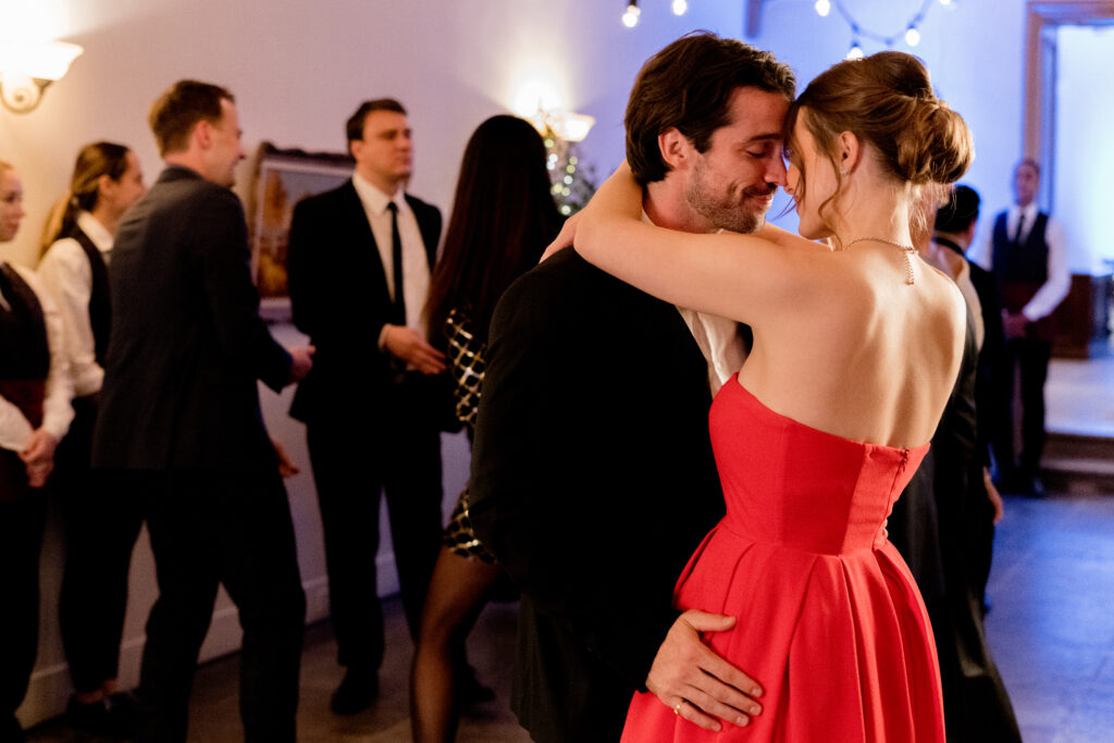 Joe Scarpellino and Celeste Desjardins kiss at christmas party in a scene from the Hallmark movie Christmas with the Knightlys