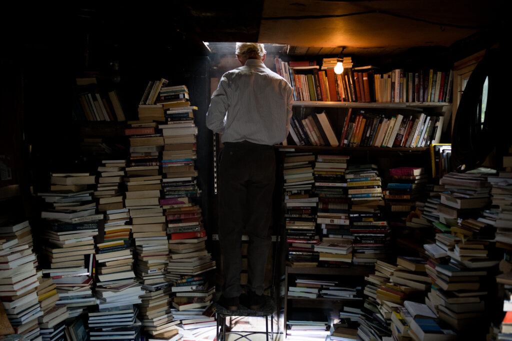 The father of Britt Lower as Miriam in Darkest Miriam stacks books in his garage
