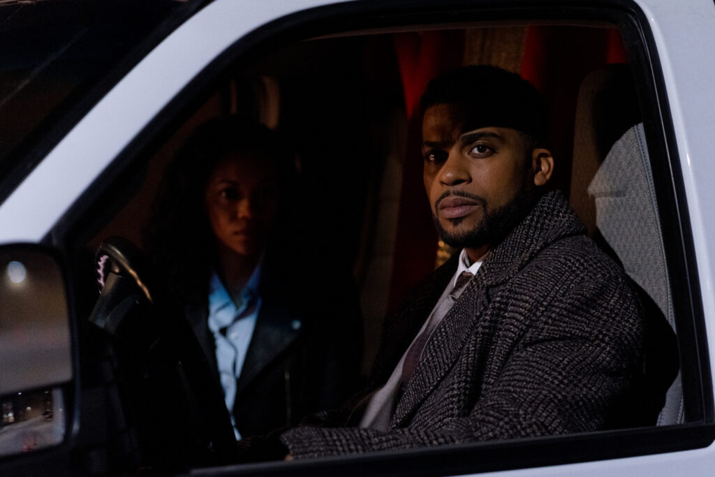 Mishael Morgan and Leland B. Martin sit in a van in a scene from Sworn Justice: Taken Before Christmas Hallmark Movie