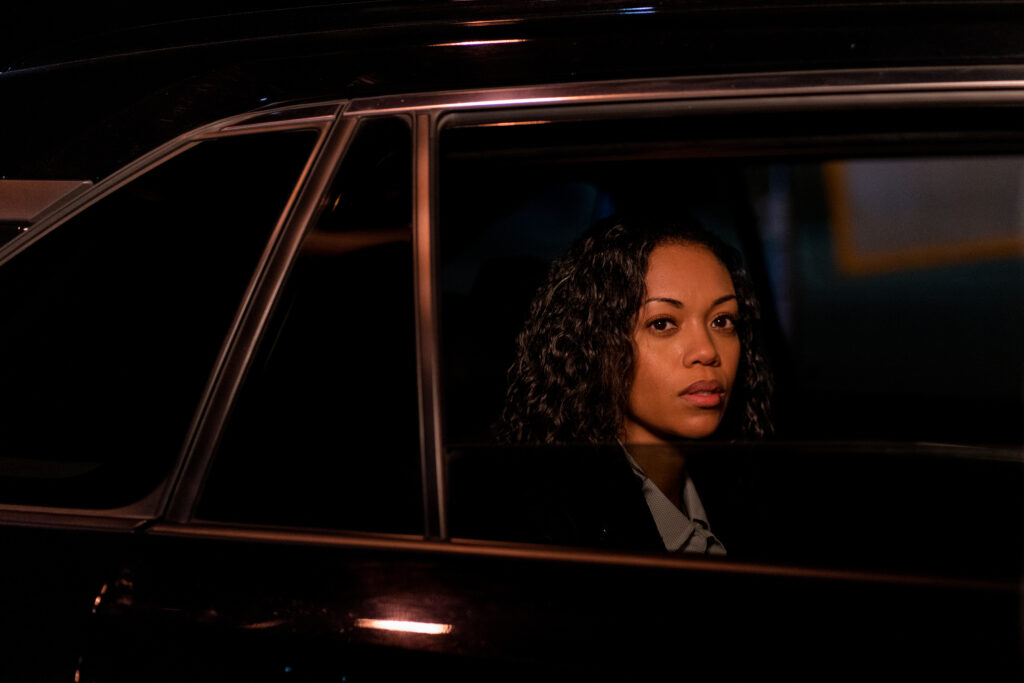 Mishael Morgan sit in a car at night looking out the window in a scene from Sworn Justice: Taken Before Christmas Hallmark Movie