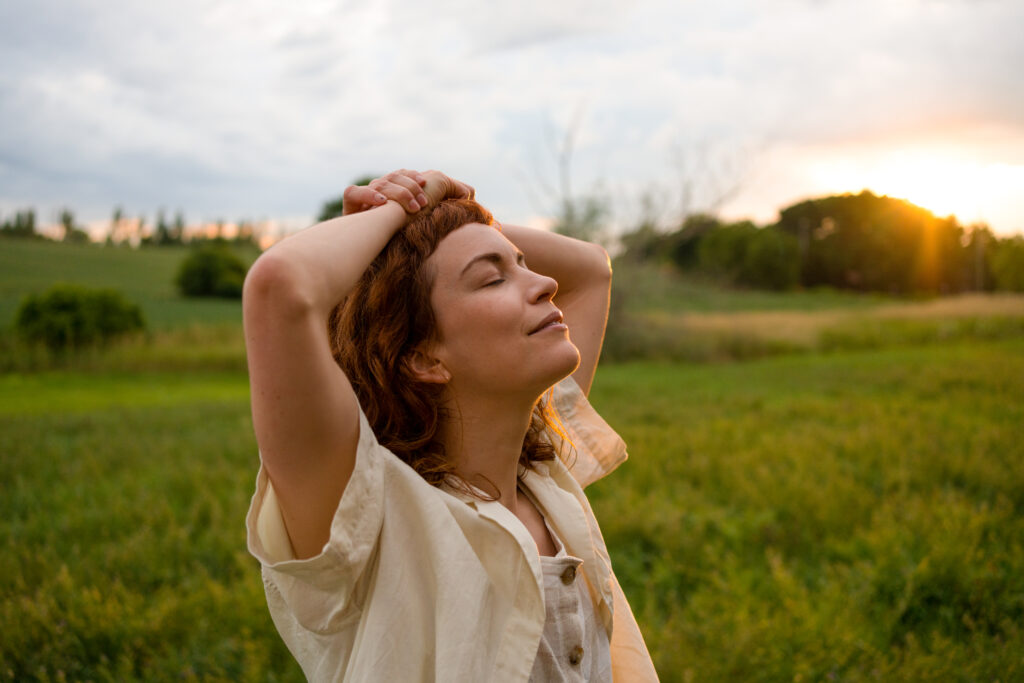 Britt Lower as Miriam in Darkest Miriam stand serenely in a field with her eyes closed