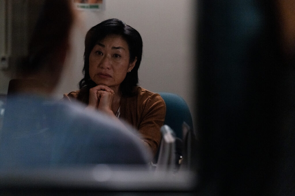 Jean Yoon as Irene Frenkle sits concerned listening to Britt Lower as Miriam in Darkest Miriam scene