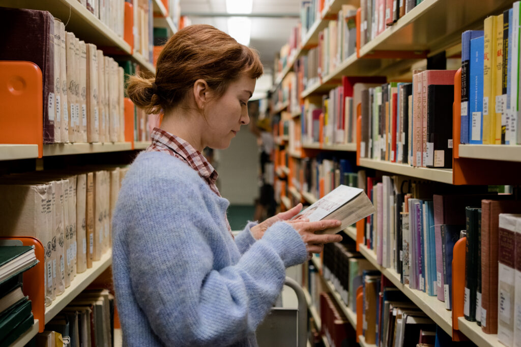 Britt Lower as Miriam reads book in library
