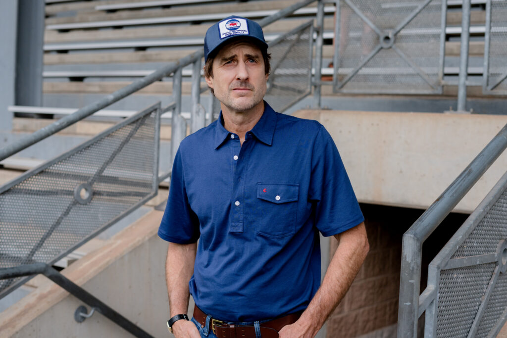 Luke Wilson entering into stadium, searching for Greg Kinnear in You Gotta Believe