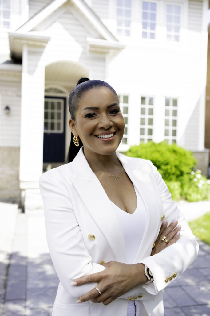 Page Turner poses for photo infront of Love it or List it house in white blazer suit