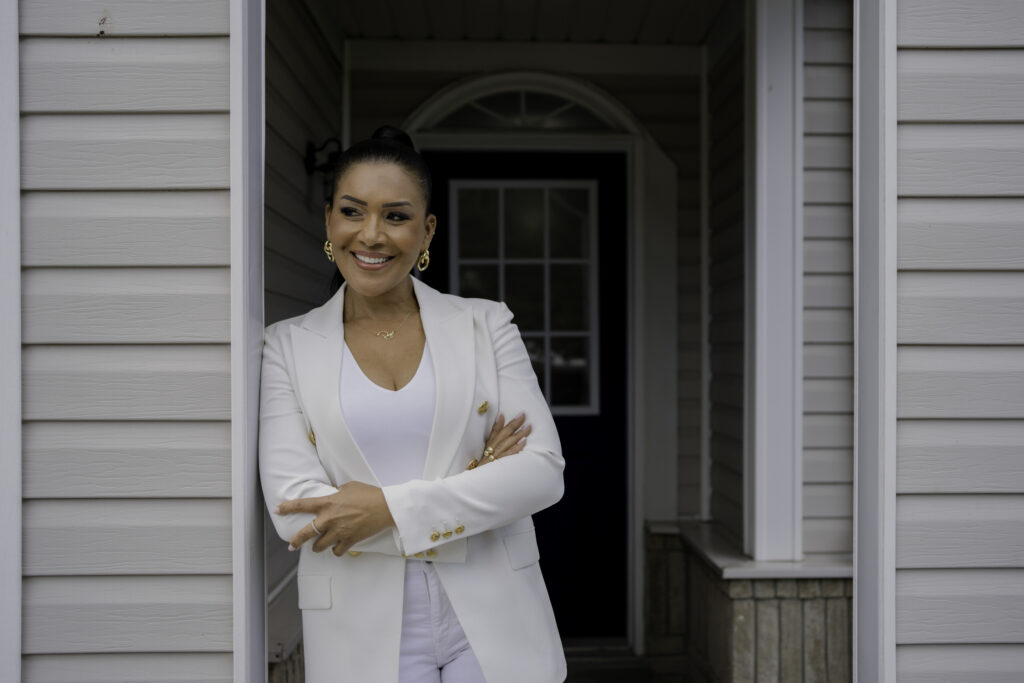 Page Turner poses for photo infront of Love it or List it house in white blazer suit