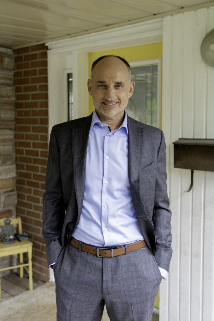 David Turner in suit poses for photo in renovated Love it or List it house