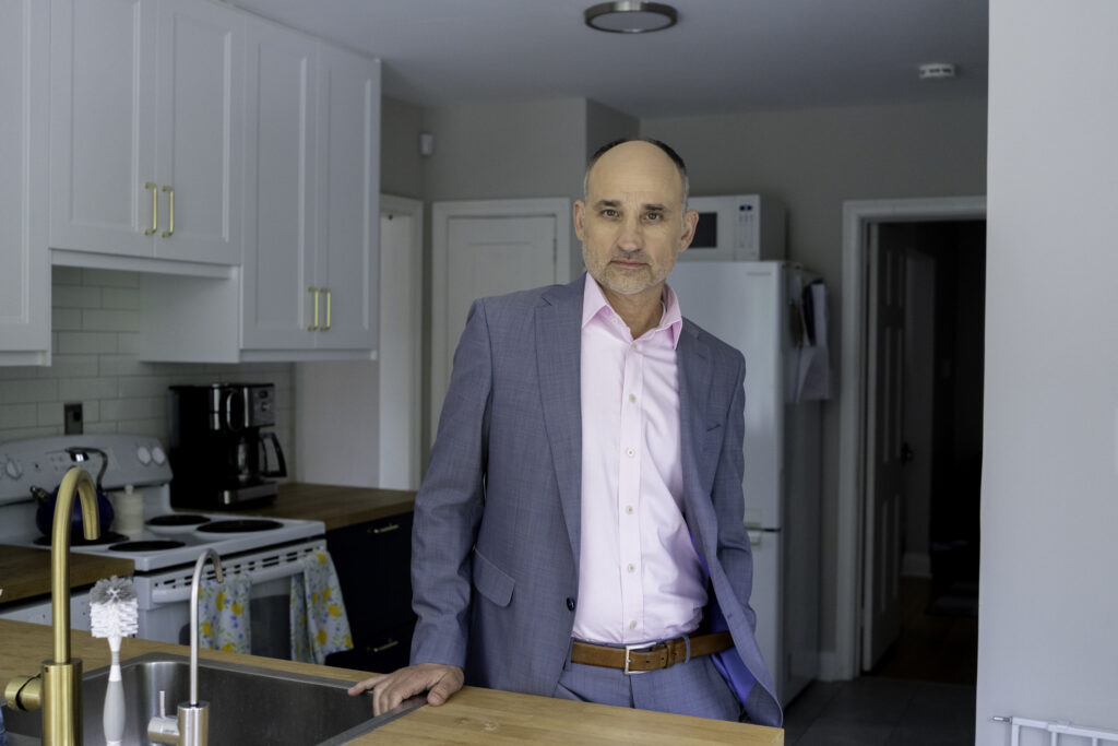 David Turner in suit poses for photo in renovated Love it or List it house