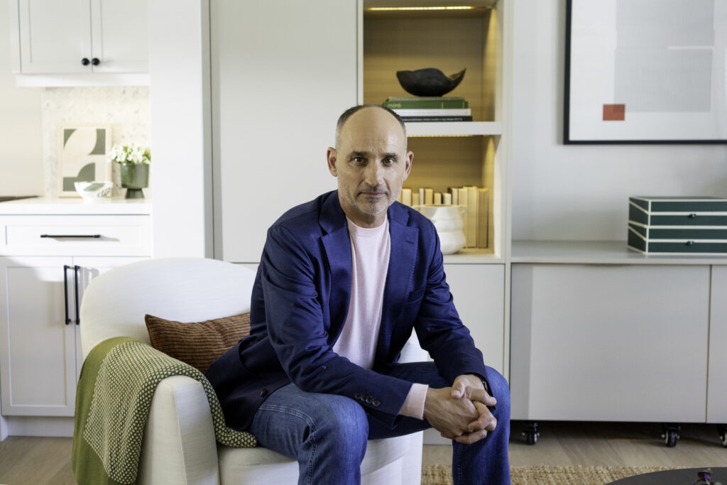 David Turner in suit poses for photo in renovated Love it or List it house