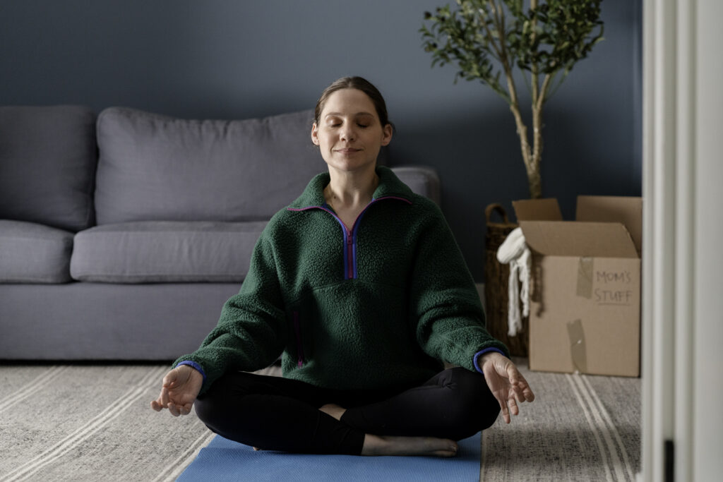 Lauren Collings in Series My Dead Mom sits meditating, doing yoga