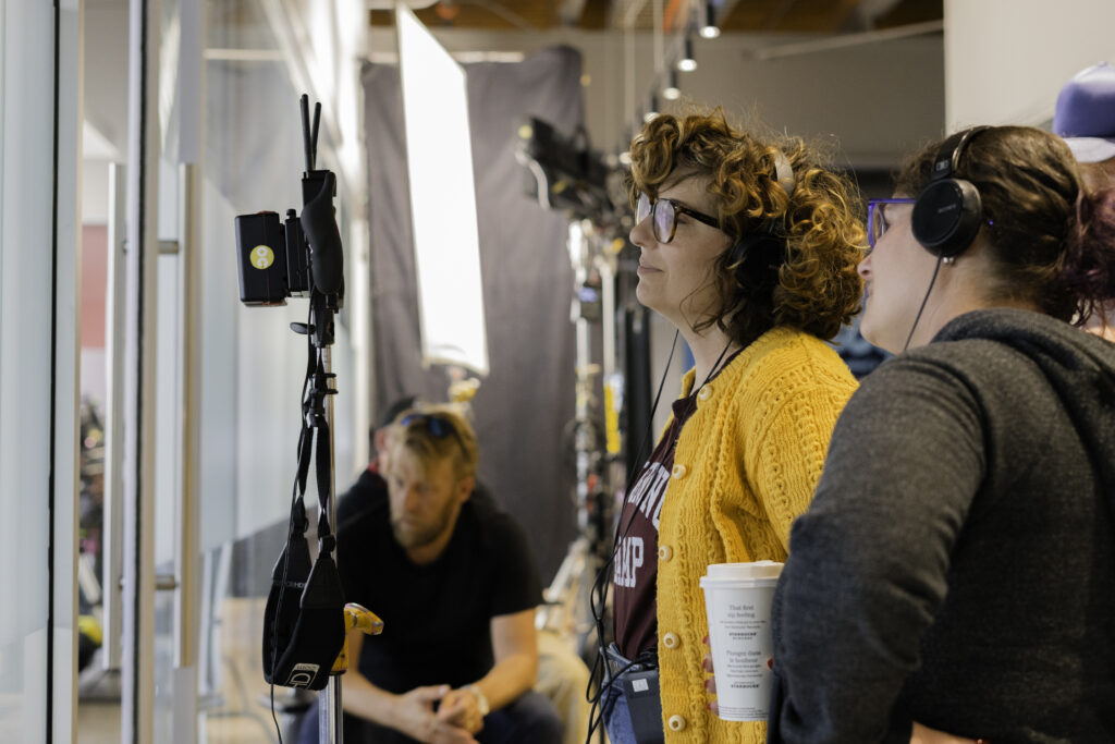 Wendy Litner, creator and director of My Dead Mom, looks at monitor screen on set