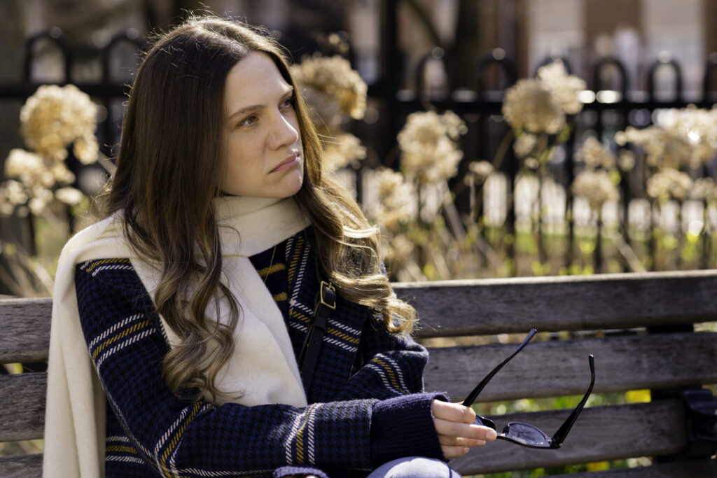 Lauren Collins from My Dead Mom sits on bench - Photo by Unit Stills Photographer Lauren Newman